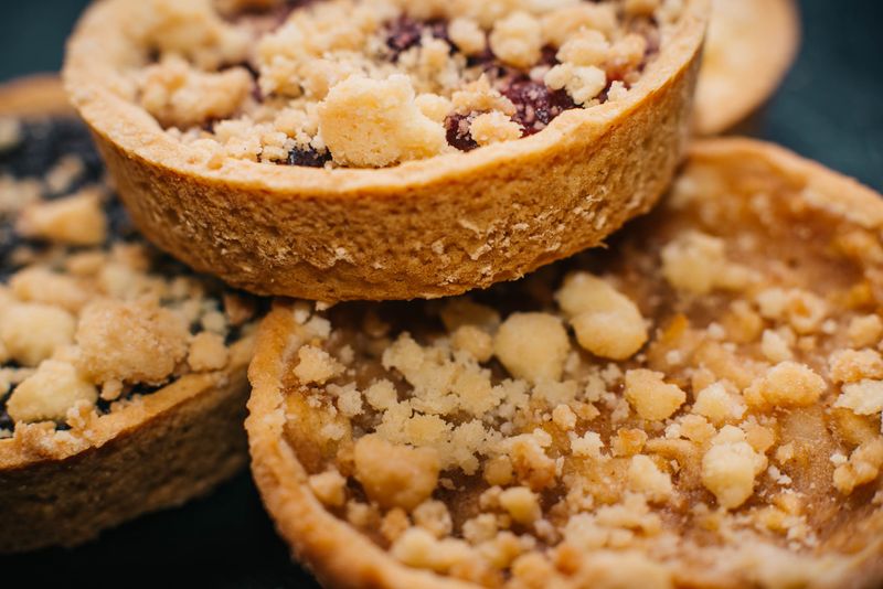 Illustrative assortment of baked fruit pies with golden crumble topping.