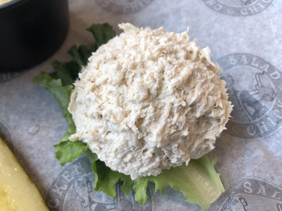 Creamy shredded chicken salad on a green lettuce leaf.