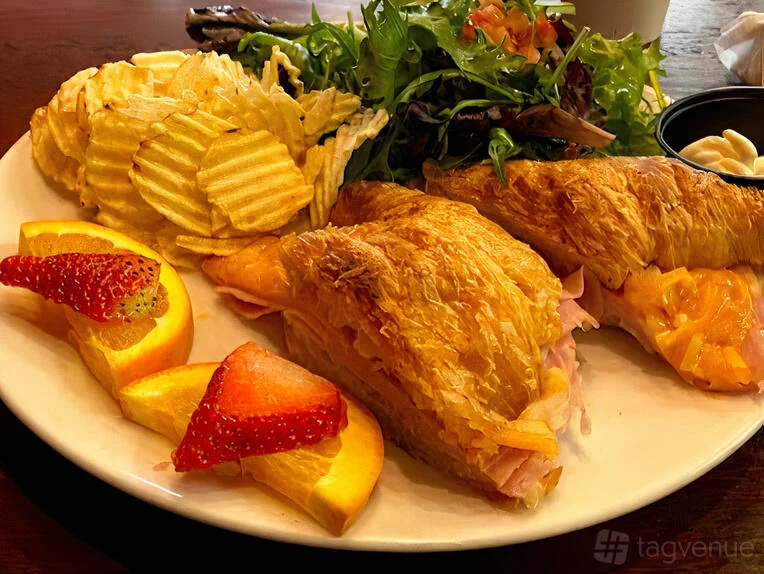 A croissant sandwich served with chips, salad and fruit at Zed’s Cafe.