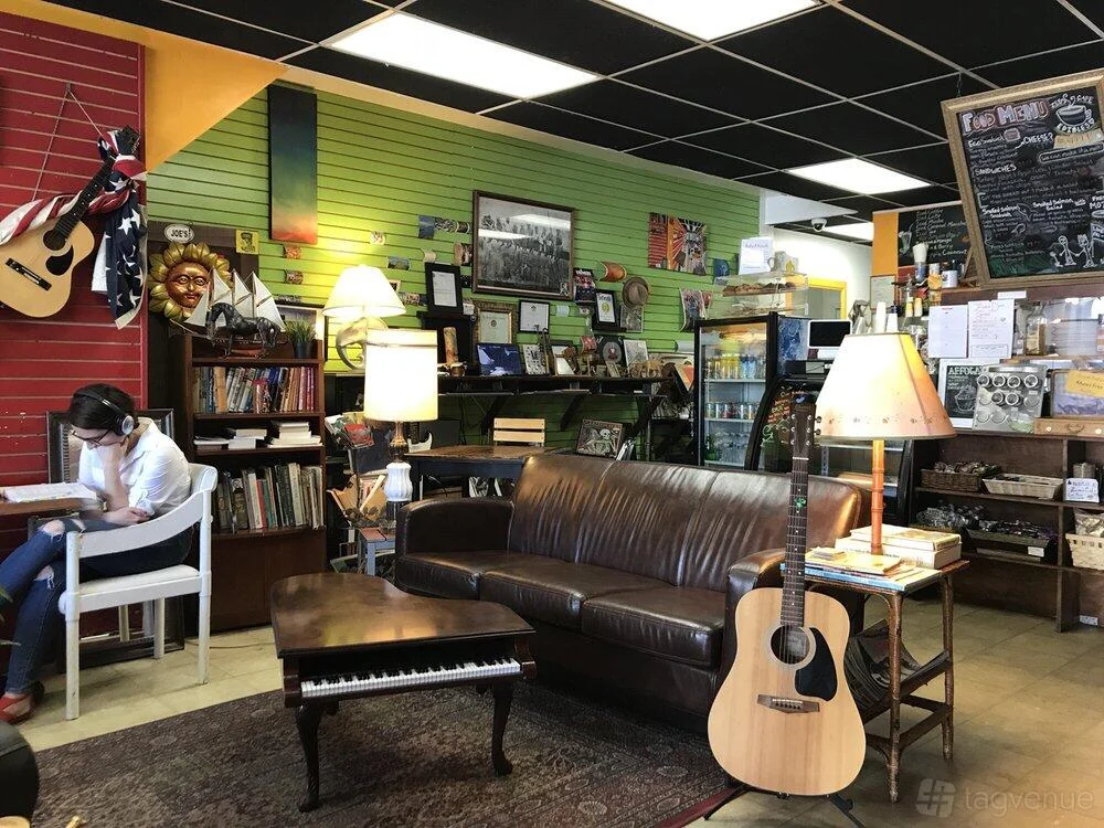 A sofa, bookshelves, guitars and the counter at Zed’s Cafe.